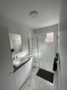 a white bathroom with a shower and a sink at A L'orée des vignes, superbe logement de 80 m2 in Wangen