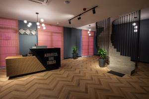 a lobby with pink walls and a counter and stairs at Address Inn in Tbilisi City