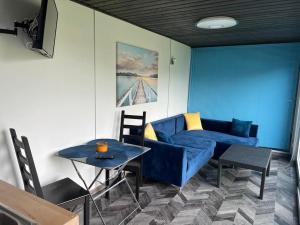吉日茨科的住宿－Domek nad jeziorem Kisajno - Giżycko，客厅配有蓝色的沙发和桌子