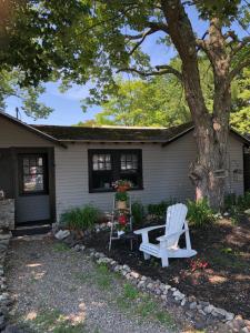 a house with a white chair and a tree at Seafarer Inn and Cottages in Old Orchard Beach