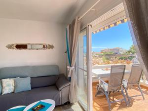 een woonkamer met een bank en een tafel en een balkon bij Litoral Burriana Apartments Casasol in Nerja