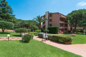 two people walking down a sidewalk in a park at Loano 2 Village in Loano