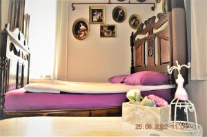 a bedroom with a large bed with purple sheets at Social Guest House in Sofia