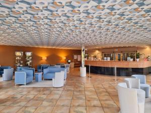 a waiting room with blue chairs and a coffered ceiling at Loano 2 Village in Loano