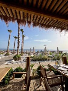 a restaurant with a view of the beach and palm trees at Royal Paradise Green Coast Resort Palase in Vlorë