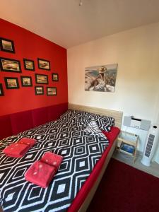 1 dormitorio con 1 cama con pared roja en Luxury Blue Porta Mare, en Dziwnówek