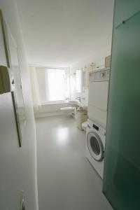 bagno bianco con lavatrice e lavandino di Splendido appartamento a due passi da Locarno a Tenero-Contra
