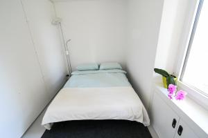 um pequeno quarto com 2 camas e uma janela em Splendido appartamento a due passi da Locarno em Tenero