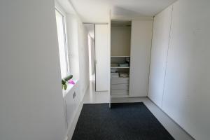 una camera con corridoio con pareti bianche e specchio di Splendido appartamento a due passi da Locarno a Tenero-Contra