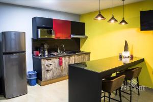 a kitchen with a refrigerator and a counter with a table at Condominio Brillante GDL in Guadalajara