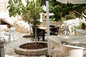 a table and chairs and a tree in a pot at Foti Rooms in Himare +64 photos