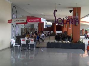 a restaurant with people sitting at tables in a building at Apartemen MTC in Manado