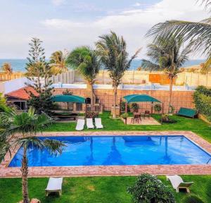 a swimming pool in a yard with palm trees at Residenza Canoa in Canoa Quebrada