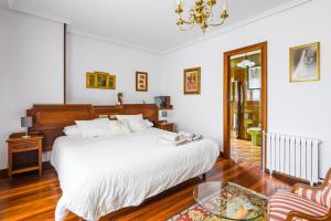 sypialnia z łóżkiem i szklanym stołem w obiekcie Villa Cecilia - Casa marinera con piscina y jardín w mieście Colindres +11 zdjęć