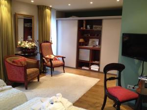 a living room with chairs and a table and a television at B&B lux Schijndel in Schijndel