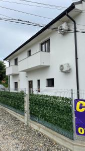 une maison blanche avec une clôture devant elle dans l'établissement Cazare Vila GOG - Rm Valcea-Salina Ocnele Mari, à Râmnicu Vâlcea