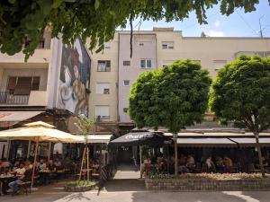 a group of people sitting at tables in front of a building at Apartman Sabah in Novi Pazar