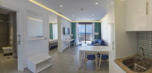 萨阿拉德洛斯阿图内斯Hotel Playa de la Plata的配有桌椅的厨房和客厅