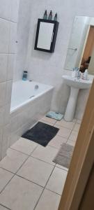 a bathroom with a bath tub and a sink at SEASCAPE MEWS 27 in Cape Town +8 photos