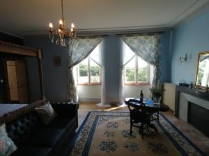 sala de estar con sofá, mesa y ventanas en Chateau de Linard, en Linard