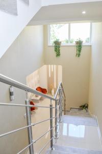 a staircase in a house with white walls and a window at Média Panzió és Apartmanház in Hajdúszoboszló