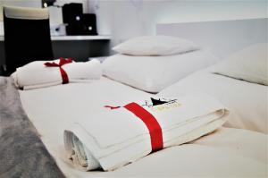 a group of three white beds with red ribbon at Apartament Cieplicka in Jelenia Góra