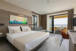 马卡尔斯卡Hotel Antonio的酒店房间里有一张白色的大床和一张书桌
