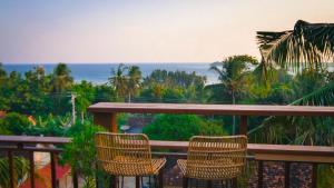 d'un balcon avec deux chaises et une vue sur l'océan. dans l'établissement BIG K HOSTEL, à Karimunjawa