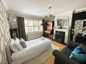 um quarto com uma cama branca e uma lareira em The Bali - 4 Bedroom House, Henley Regatta em Henley on Thames