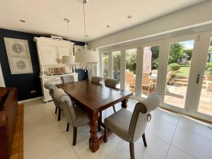 a dining room with a wooden table and chairs at The Bali - 4 Bedroom House, Henley Regatta in Henley on Thames