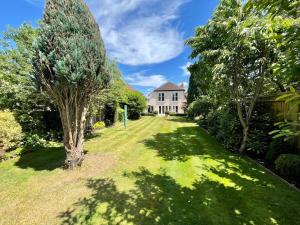 a large yard with a house and trees at The Bali - 4 Bedroom House, Henley Regatta in Henley on Thames