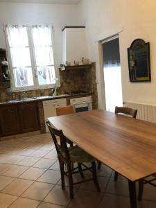 een keuken met een grote houten tafel en stoelen bij Maison de casteljaloux 9 personnes in Casteljaloux
