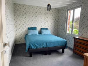 a bedroom with a bed with blue sheets and a window at Gaston en Baie in Villers-sur-Authie +35 photos