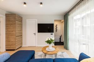 a living room with a blue couch and a table at D&D apartments 4 in Palanga