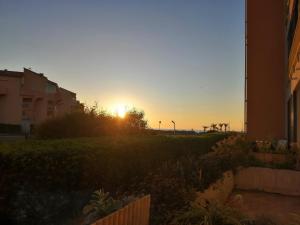 a sunset in a city with the sun setting at Palm Beach in Le Barcarès