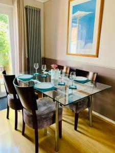 comedor con mesa de cristal y sillas en The Lake House, Woking, en Woking