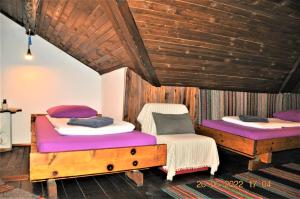two beds in a room with wooden ceilings at Social Guest House in Sofia