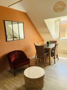 een woonkamer met een tafel en een stoel bij Appartement Cosy en coeur de vieille ville in Boulogne-sur-Mer
