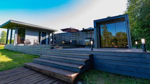 a home with a deck and a house with windows at KääraPesa in Vihtra