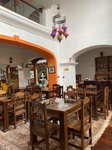 a restaurant with wooden tables and chairs and a chandelier at Indian Palace Hotel Boutique Spa & Restaurante in Antigua Guatemala