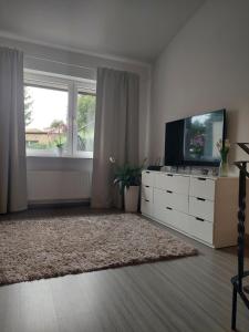 a living room with a tv and a large window at Christiana Andersena - apartamenty in Poznań