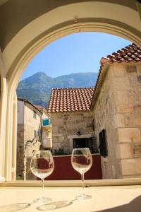 two wine glasses sitting on a table in front of a window at CENTER (THE HEART) OF MAKARSKA in Makarska