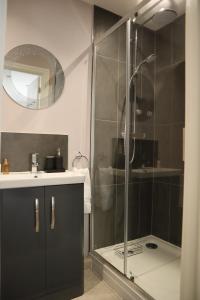 ein Bad mit einer Dusche und einem Waschbecken in der Unterkunft The Gardens Room in Upton