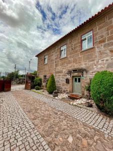 une maison en briques avec une allée en pierre en face de celle-ci dans l'établissement Casa Grande do Seixo, à Vidago