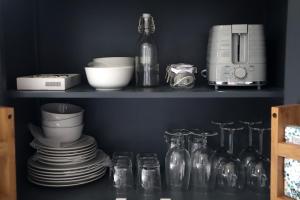 a shelf with plates and cups and a blender at The Gardens Room in Upton