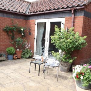 eine Terrasse mit einem Stuhl und einigen Topfpflanzen in der Unterkunft The Gardens Room in Upton