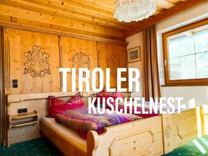 Bett in einem Zimmer mit Holzwänden in der Unterkunft Merryshof in Sankt Ulrich am Pillersee