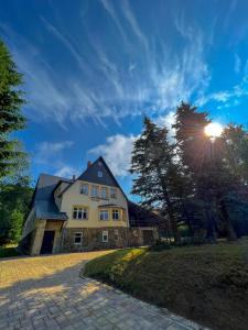 Resort LUFT Sněžník في Sněžnik: منزل كبير مع الشمس في السماء