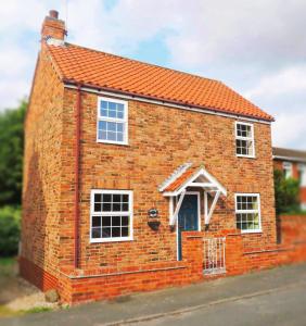 uma casa de tijolos vermelhos com um telhado laranja em Chapel Bricks-dog friendly cottage near the coast em Withernwick