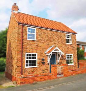 a red brick house with an orange roof at Chapel Bricks-dog friendly cottage near the coast in Withernwick